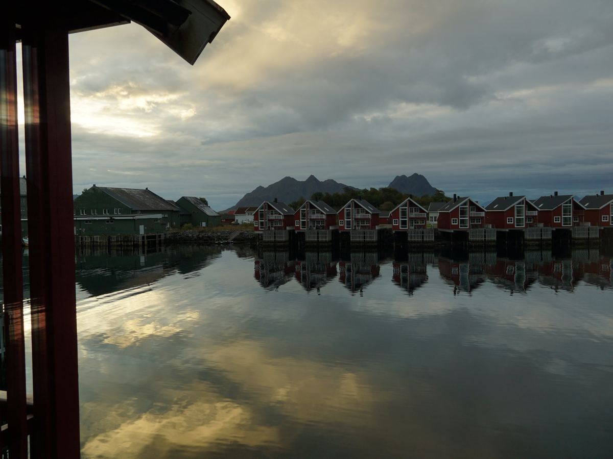 Le case rosse dei pescatori riflesse nel porto, alle isole Lofoten