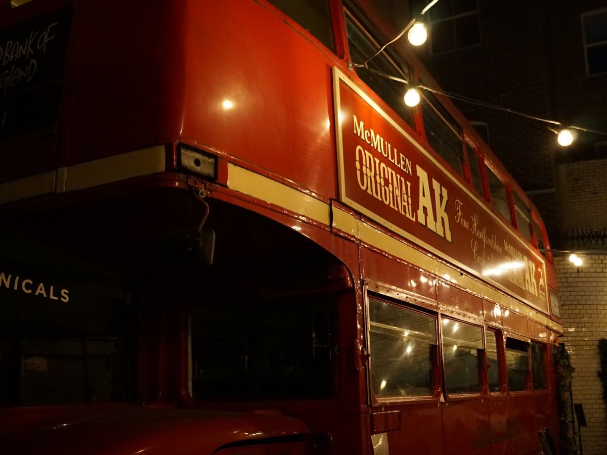 Un vecchio autobus rosso a due piani illuminato di sera, a Londra