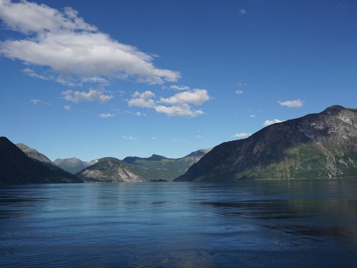 Un fiordo norvegese calmo sotto il cielo azzurro